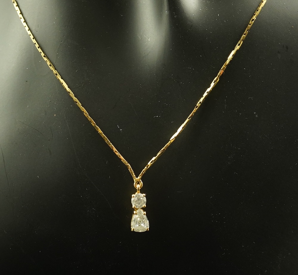 A modern gold and two stone diamond pendant